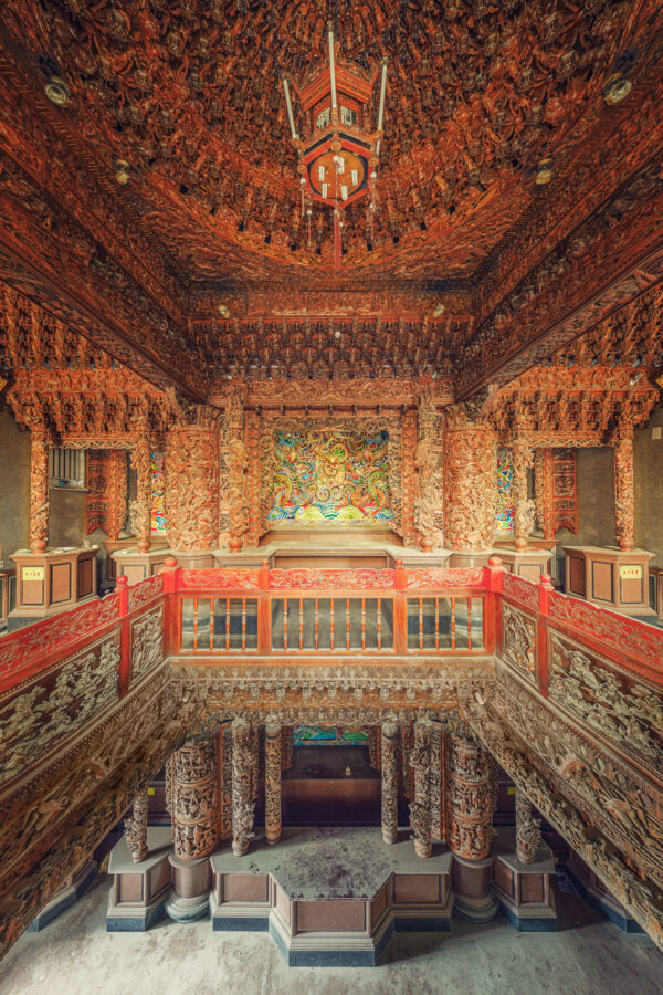 ..this abandoned temple in Taiwan showcases intricate wood carvings, now faded and worn, yet still revealing the grandeur of its past. The ornate altar, adorned with numerous dragon motifs, stands as a testament to its former spiritual significance. -