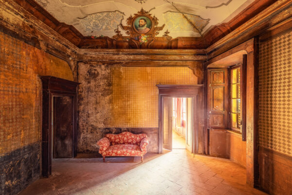 Peeling walls and shadows dominate the deserted estate, leaving only the faint impression of past beauty. -