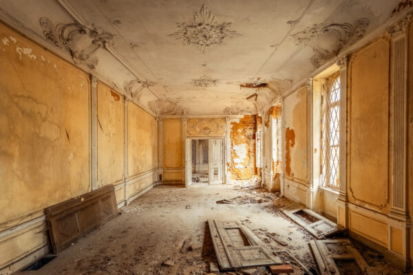 Sunlight filters through broken windows, illuminating a forgotten room in a once-glorious castle. -