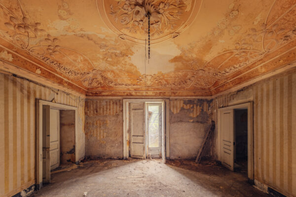 A once-grand room in an abandoned villa lies in disrepair. -