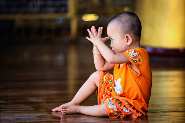 A child learning the basics in buddhism, taken at the Shwedagon Pagoda in Yangon / Myanmar. -
